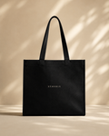 Model carrying XEMORIX XMRX-035 black signature tote bag with centered logo on clean luxury background