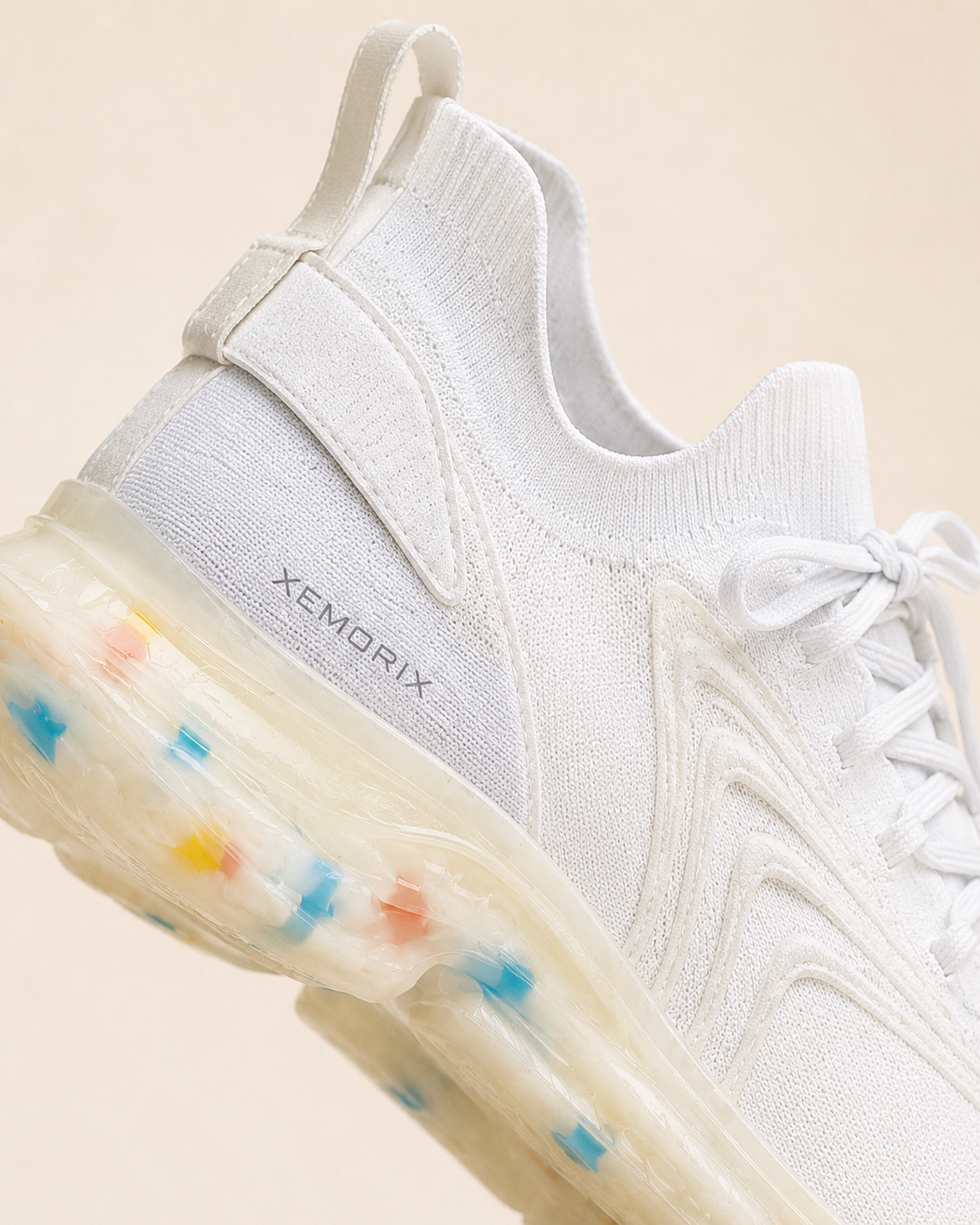 XEMORIX XMRX-070 Signature Motion Sneaker in white with a translucent sole and subtle side logo on a beige luxury studio background.
