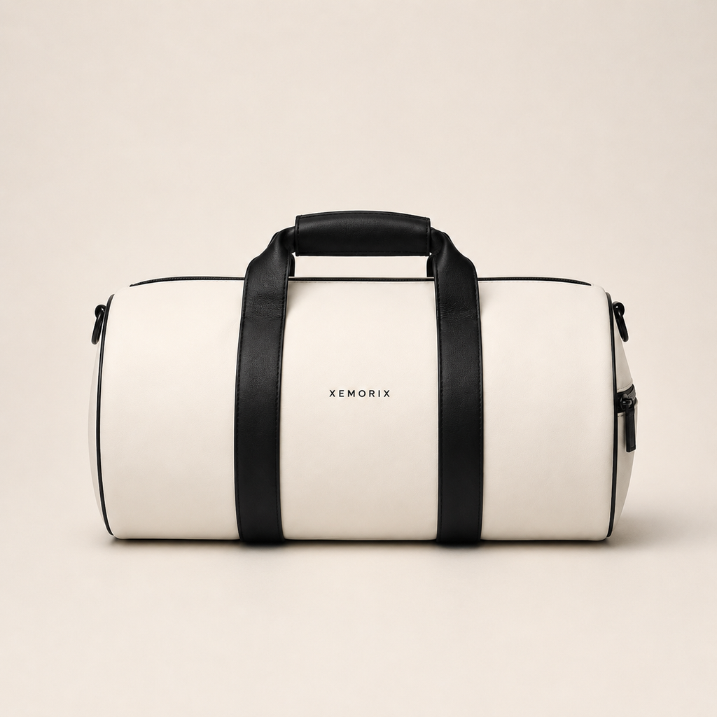 White and black XEMORIX Signature Duffel Bag with centered logo, black straps, zipper pocket, and luxury travel design.