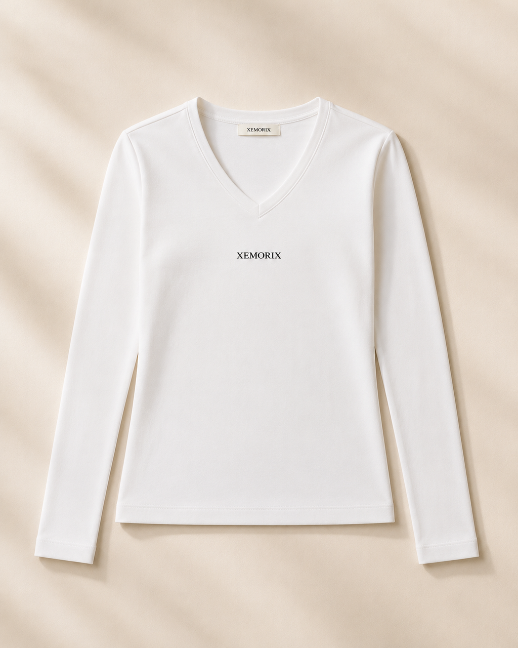 XEMORIX XMRX-048 white V-neck long sleeve top with centered black logo on cream luxury background