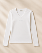 XEMORIX XMRX-048 white V-neck long sleeve top with centered black logo on cream luxury background